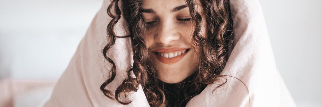 photo of woman smiling and wrapped in blanket