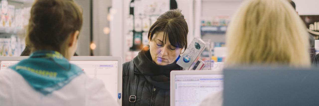 I Had a Public Breakdown in a Store During the COVID-19 Pandemic photo of middle aged woman in pharmacy being served by two cashiers