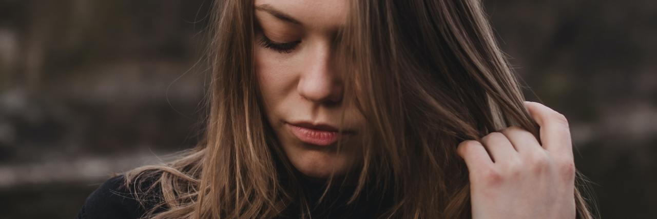 What It's Like to Have Anorexia as a Reform Jew photo of woman with dark blonde hair looking down with one hand in her hair
