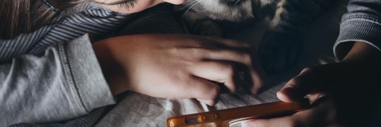 Fibromyalgia and Social Media During the COVID-19 Pandemic A woman and her cat looking at her phone