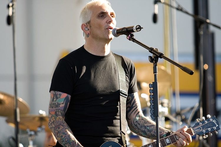 Art Alexakis sings onstage while playing the guitar