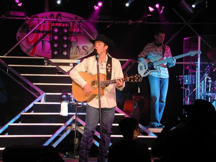 Clay Walker performs onstage with a guitar