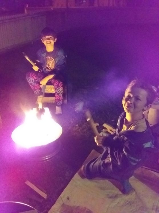 kids sitting around campfire 