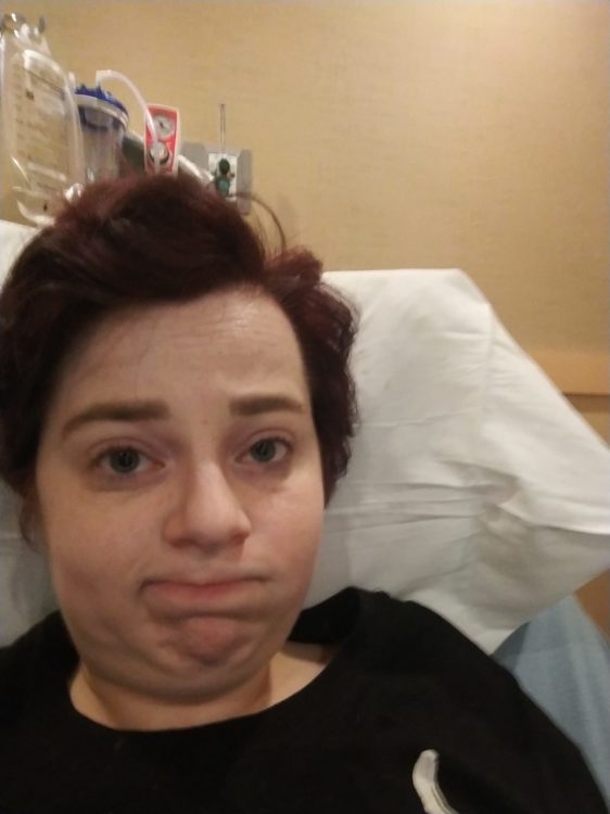 A person with short brown hair sits at an urgent care