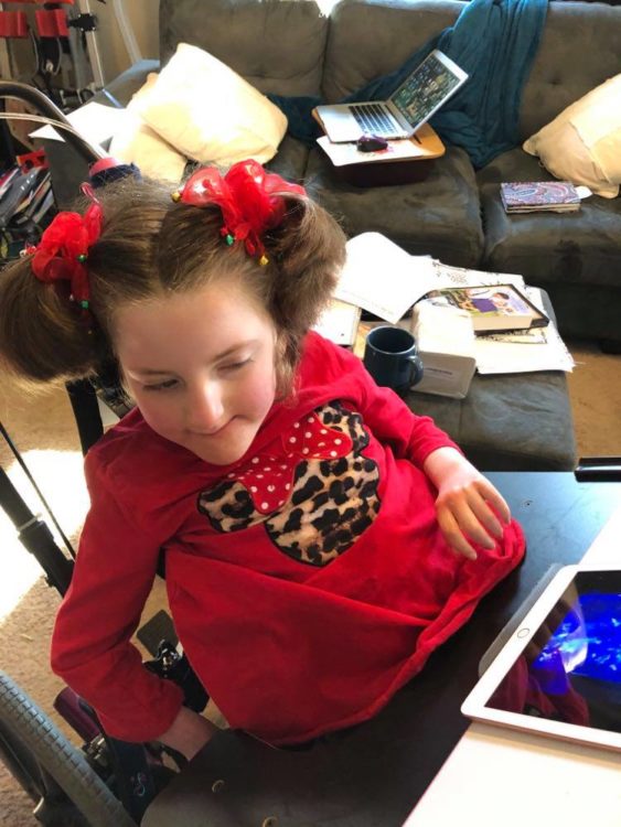 A young girl sitting in her living room.