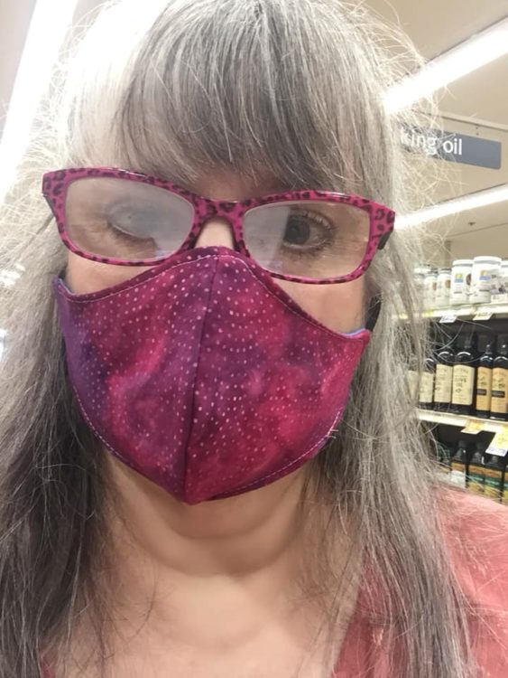 woman wearing pink glasses and a pink face mask