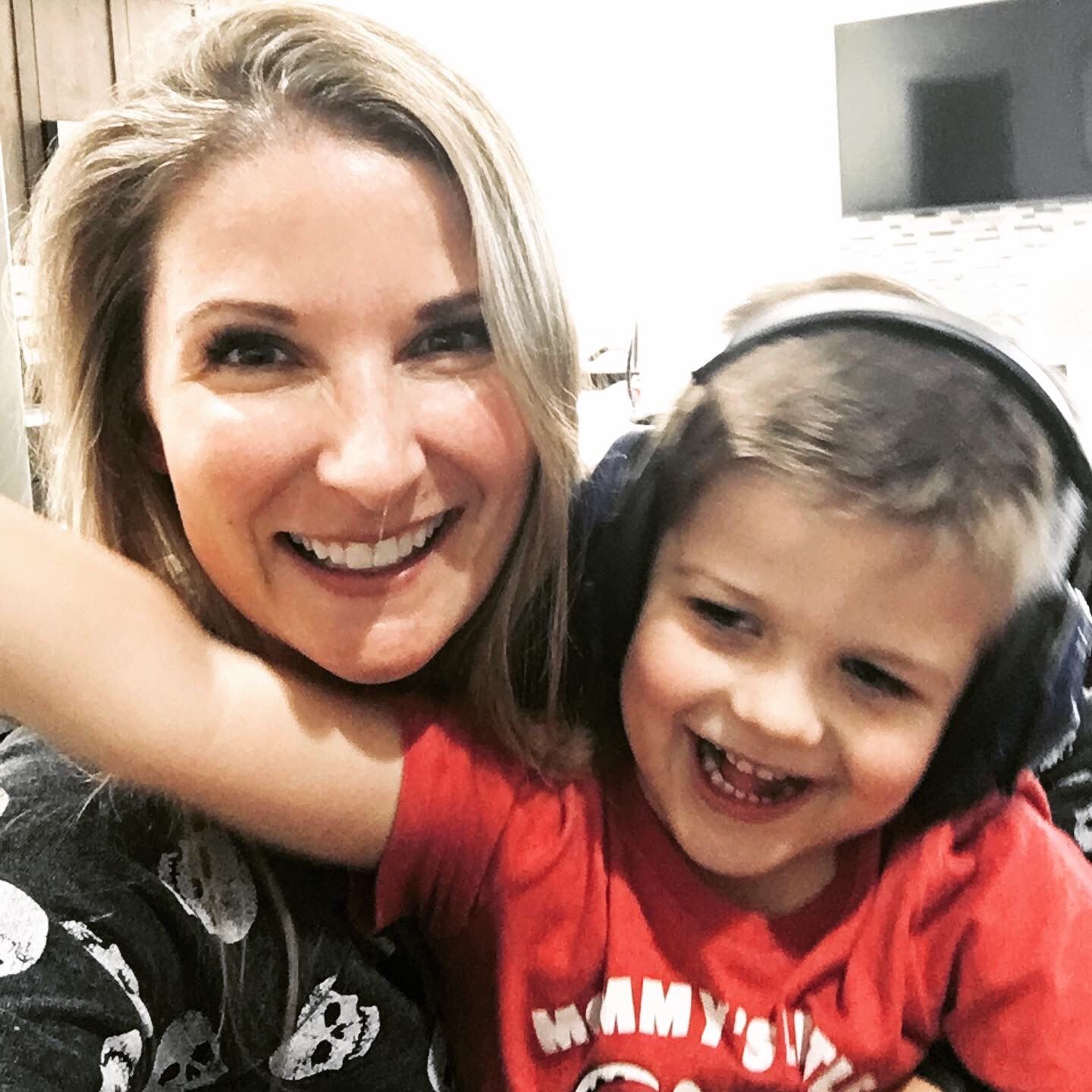 Lauren with her son. He is wearing noice-canceling headphones.