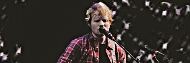 Ed Sheeran performs at a festival in a plaid shirt