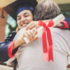 a graduate hugging her father