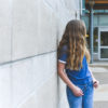 a girl standing alone in the school yard