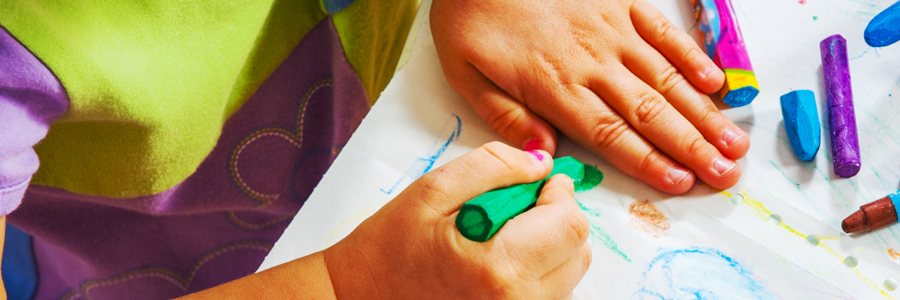 Teaching Self-Care Skills to Children During the COVID-19 Pandemic Child drawing with crayons.