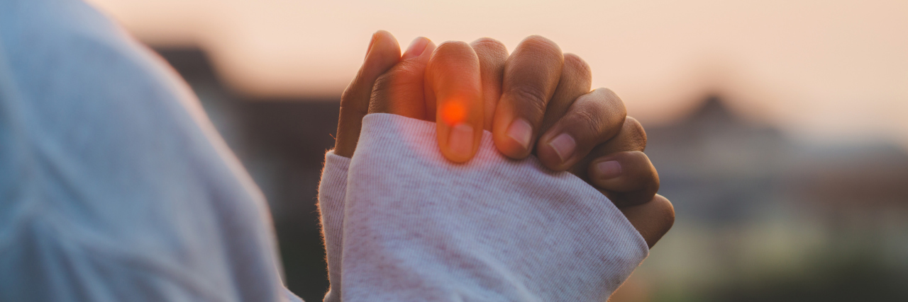 What It's Like Being Religious With Borderline Personality Disorder A woman praying outside