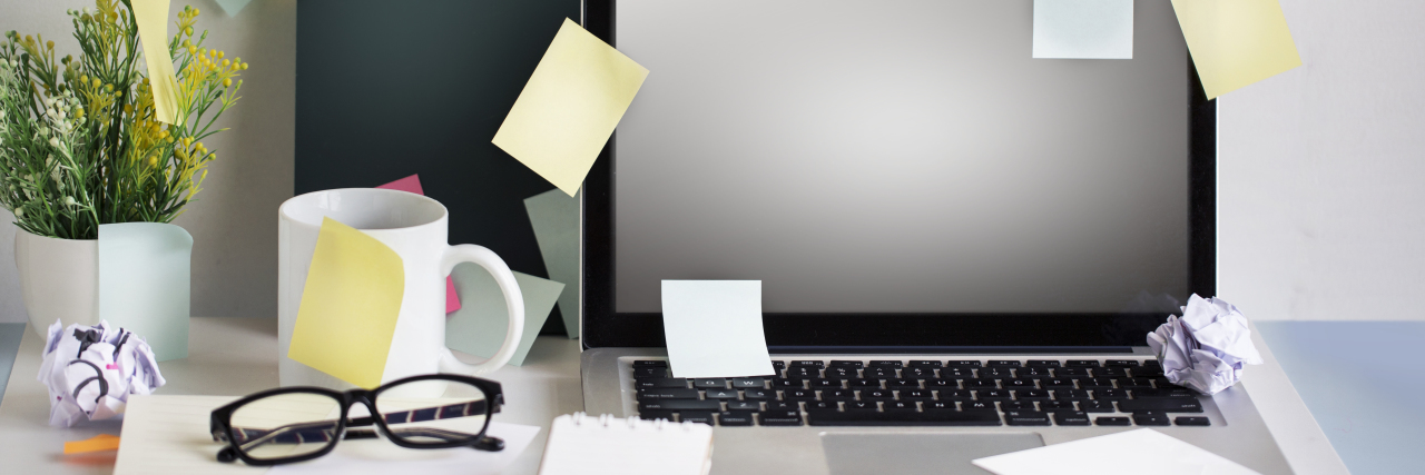 The Gift of an Adult ADHD Diagnosis Messy office desk with many blank sticky notes.