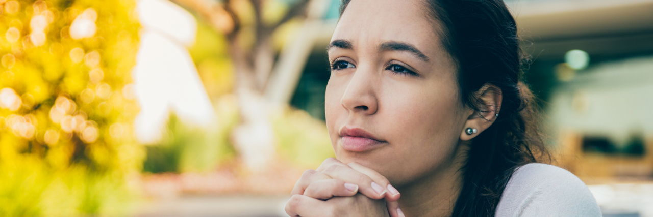 Woman sitting outside thinking.