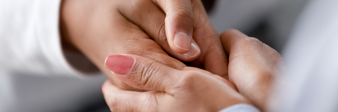 Woman holding child's hands.