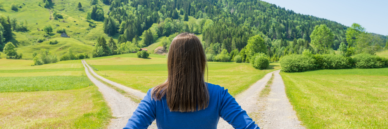 The Toll My Learning Disability Takes on My Sense of Direction A woman standing at a deserted crossroad.