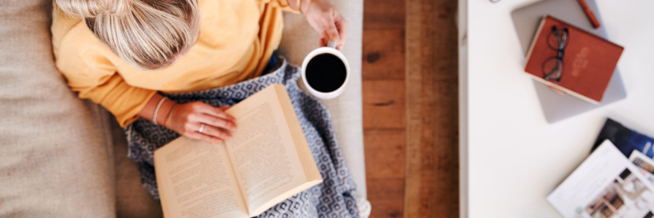 COVID-19: Self-Care Ideas for Stressed Out Moms a woman reading a book with her hair up