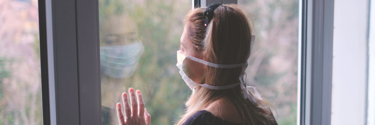 Using the Lessons of COVID-19 to Make the Future Better Woman wearing a mask looking out the window during the coronavirus pandemic.