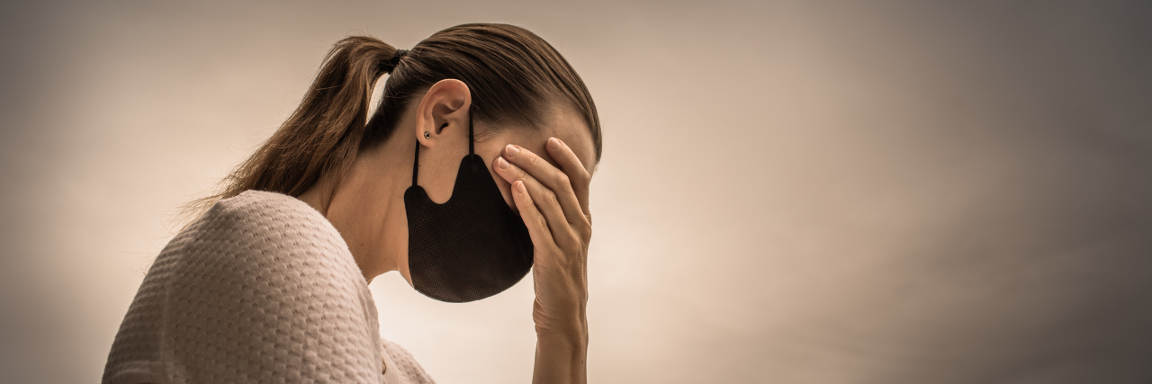 Being Quarantined at Home During the COVID-19 Pandemic With Adult Kids A woman with a face mask feeling stressed.