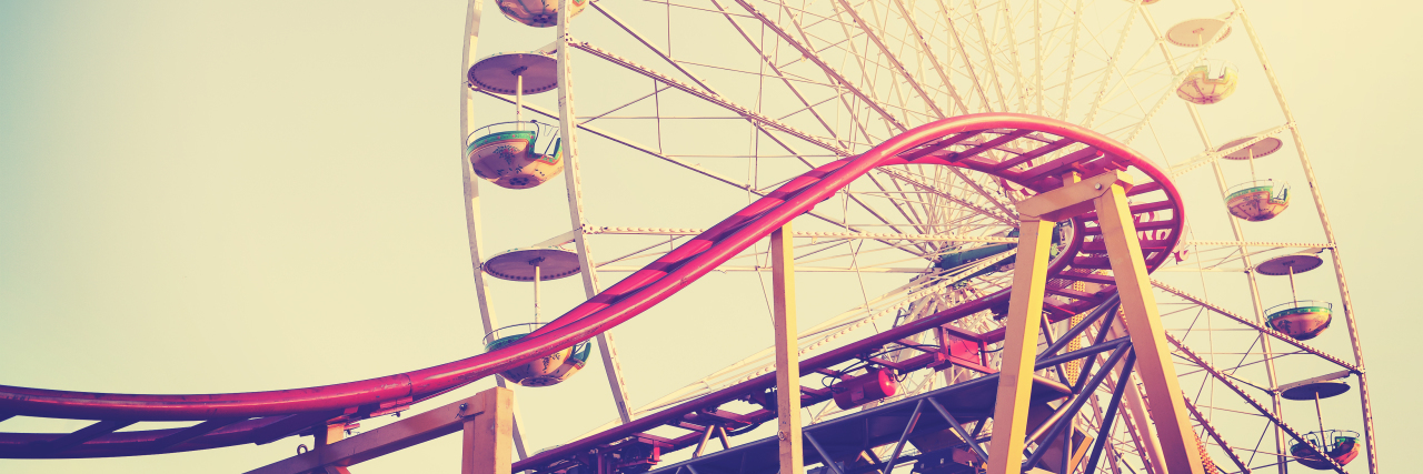 Retro vintage instagram stylized picture of a rollercoaster and ferris wheel