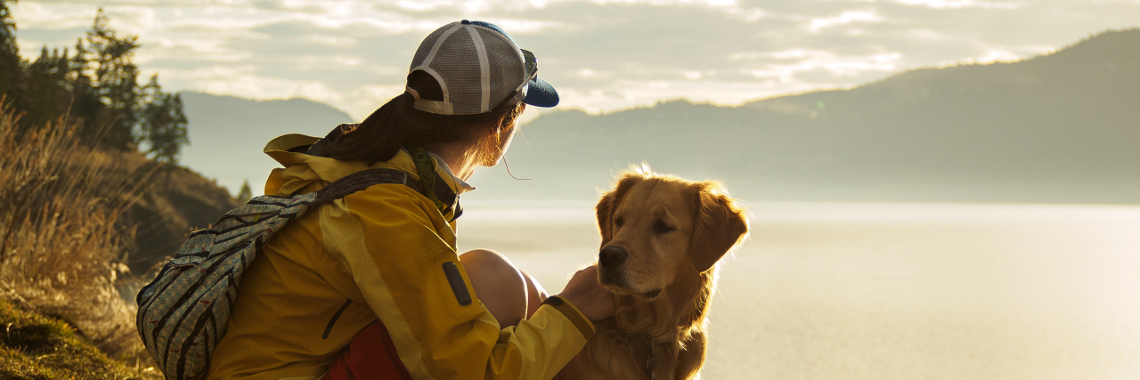 Shifting From Awareness to Acceptance of My Autism Young woman hiking with her dog.