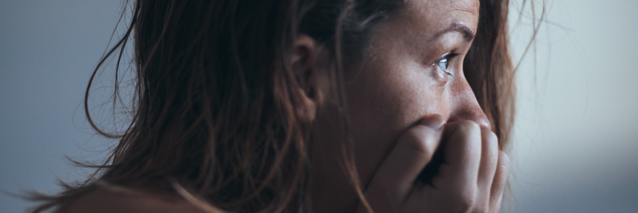 How to Heal from the Trauma of COVID-19: Tips Close-up of a woman with her head in her hands, looking straight ahead
