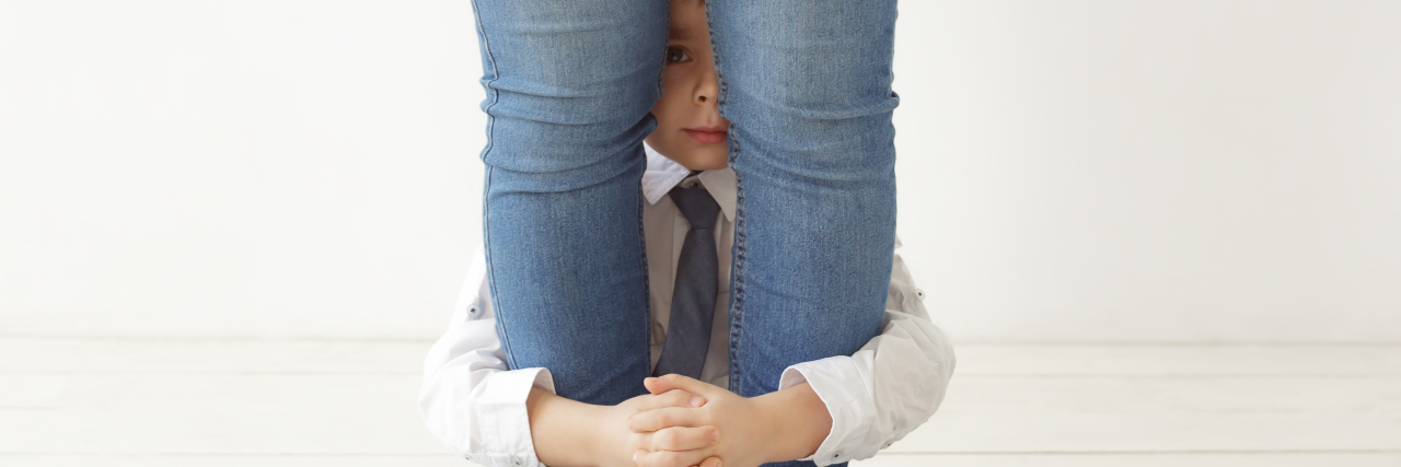 How I'm Managing My Anxiety and Parenting During COVID-19 A little boy is sitting on the floor hugging his mom's legs