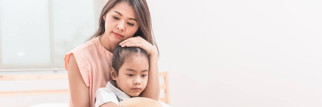 Ask Your Kids How They're Feeling About the COVID-19 Pandemic Asian mother hugging and comforting her sad daughter.