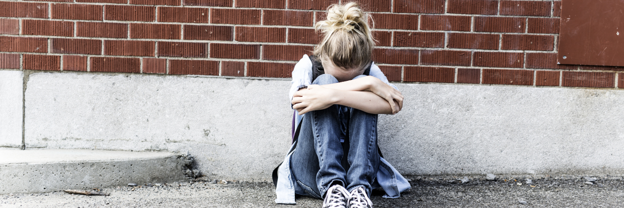 Recovering From PTSD After Bullying as Someone on the Autism Spectrum Sad girl with autism being bullied at school.