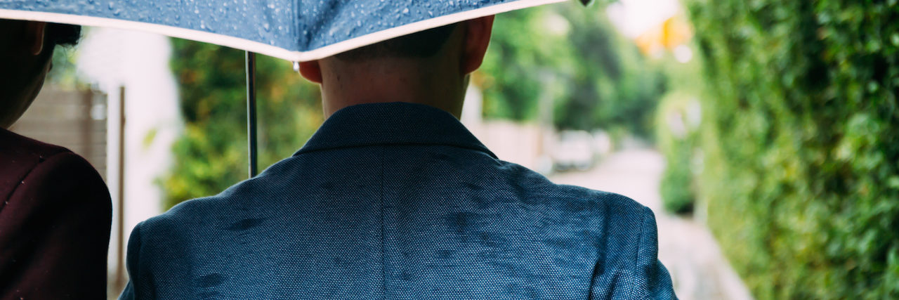 How My Cousin's Death by Suicide Affected Me and My Family A man walking under an umbrella