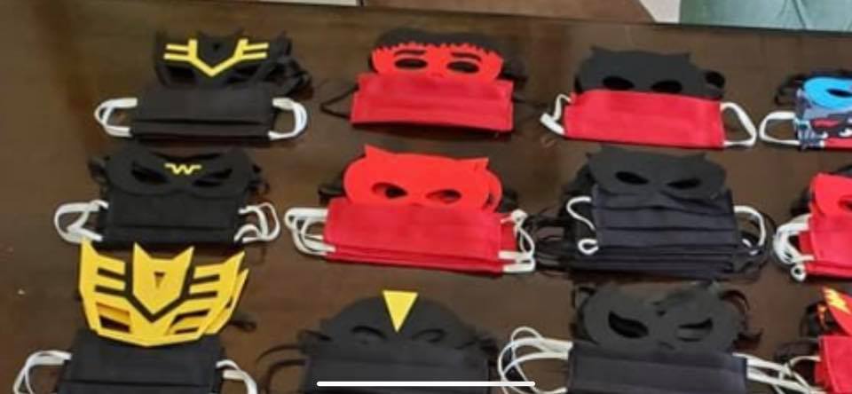 Stacks of kids' face masks styled like superhero masks