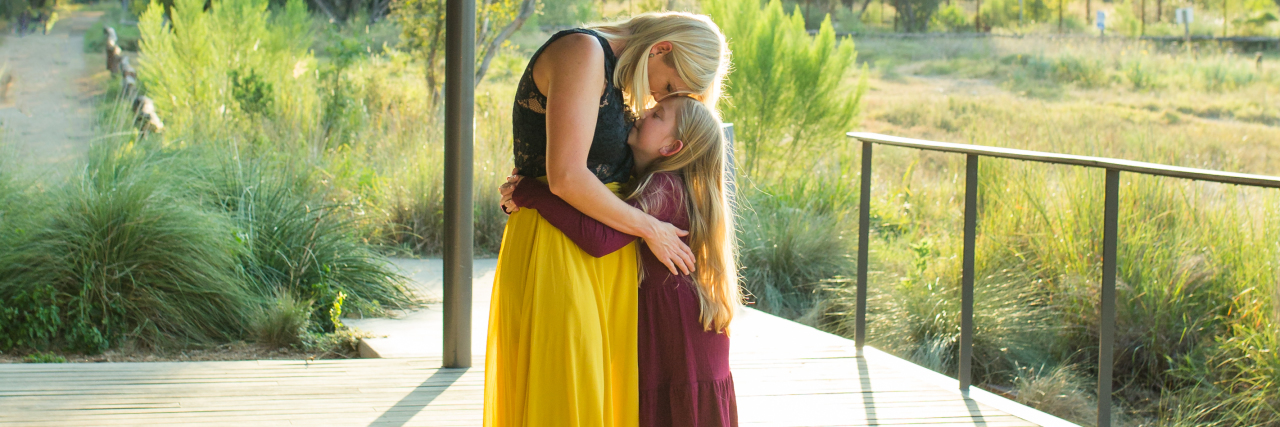 5 Self-Care Tips for Mothers of Kids With Disabilities A mom hugging her daughter with a disability.