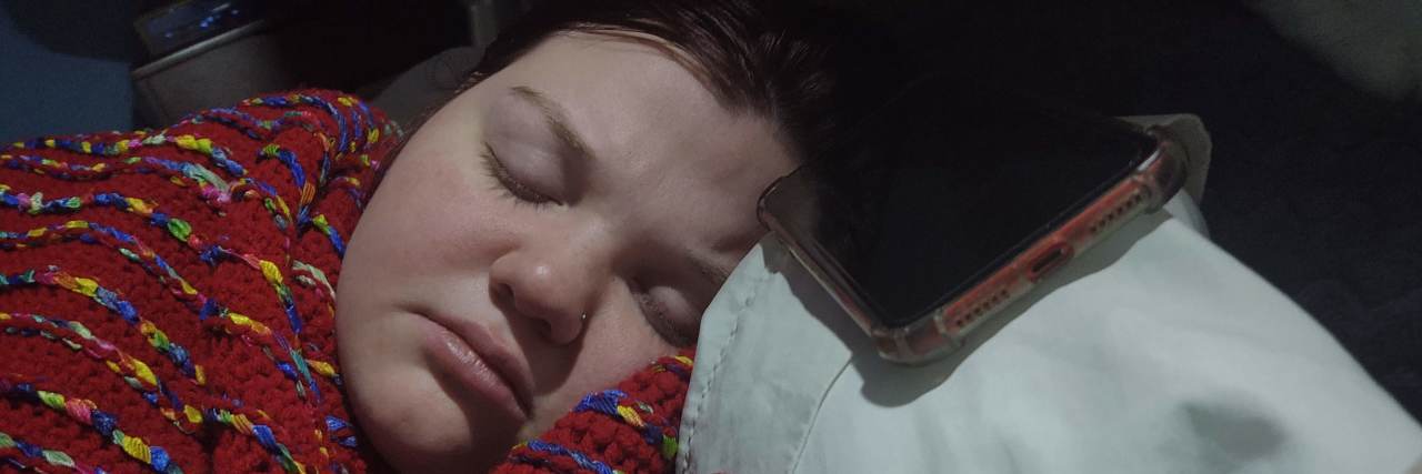 How Living Through a Pandemic Can Make You Exhausted Woman sleeping with phone next to her