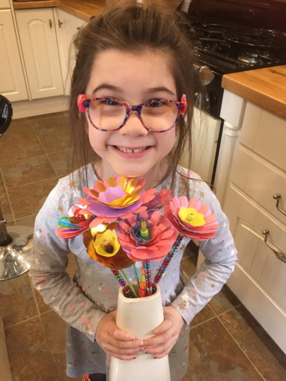 little girl holding paper flowers