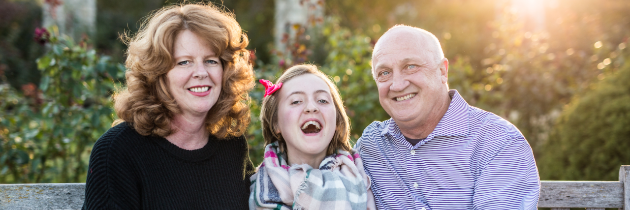 How We're Holding On To Hope for Our Child With a Rare Disease the parents of Elouise and Elouise, sitting and smiling