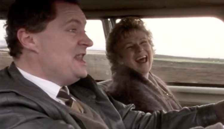Two characters from The Wedding Gift laugh in a car