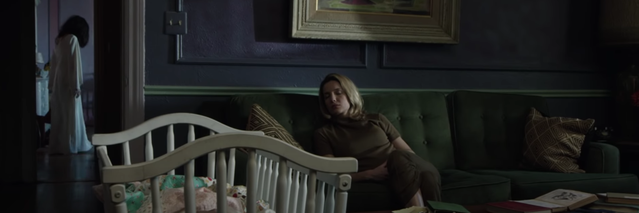 Why I Use Horror to Take Control of My Anxiety screenshot of scene from Annabelle movie showing woman asleep on sofa with ghost in background