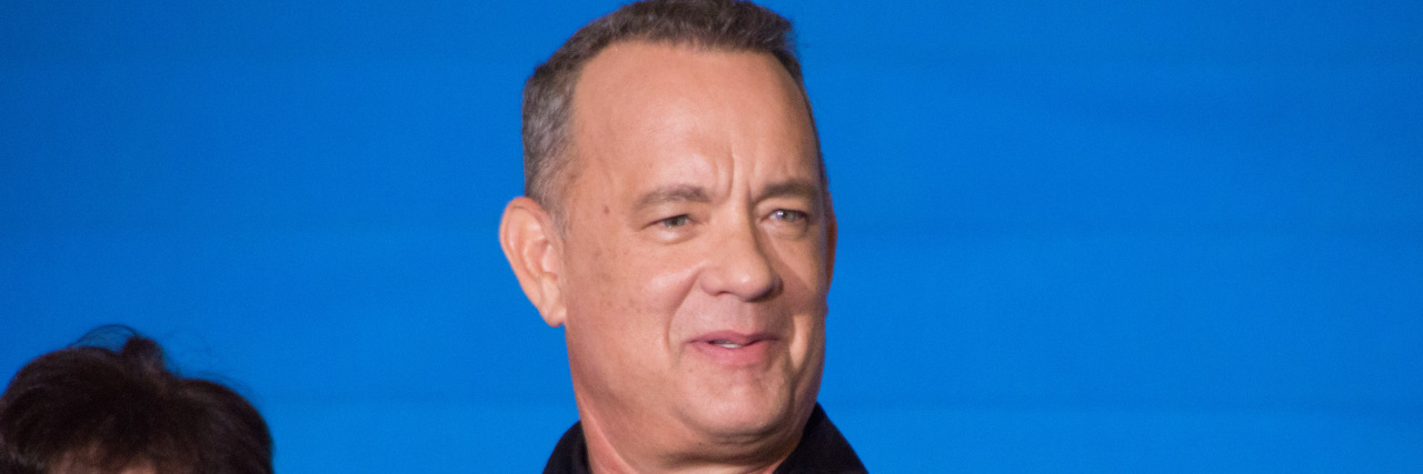 Tom Hanks in a black shirt at a promotional event for a film