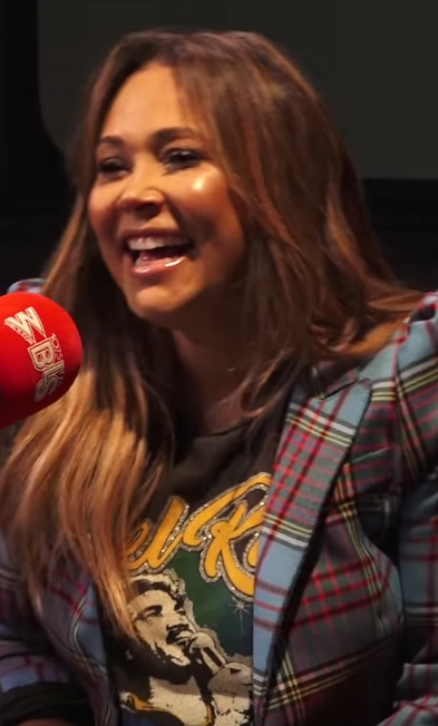 Tamia Hill speaks into a microphone at a radio show