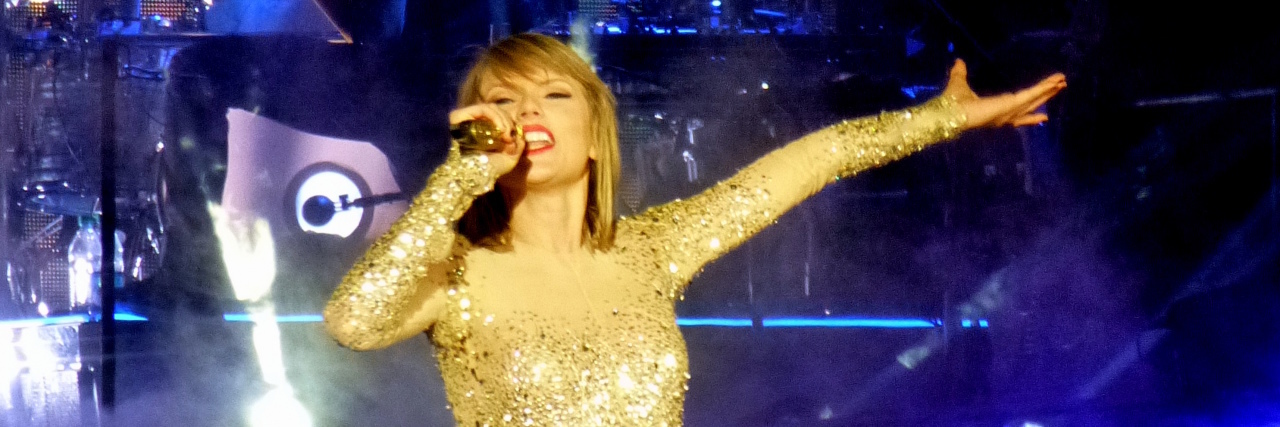 Taylor Swift performs onstage in a glittery bodysuit