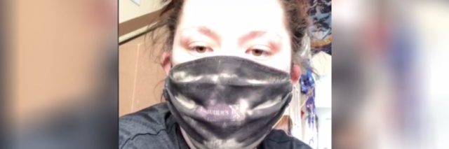 White woman with brown hair tied back wearing a black face masks that's beginning to reveal the Marauder's Map from Harry Potter.