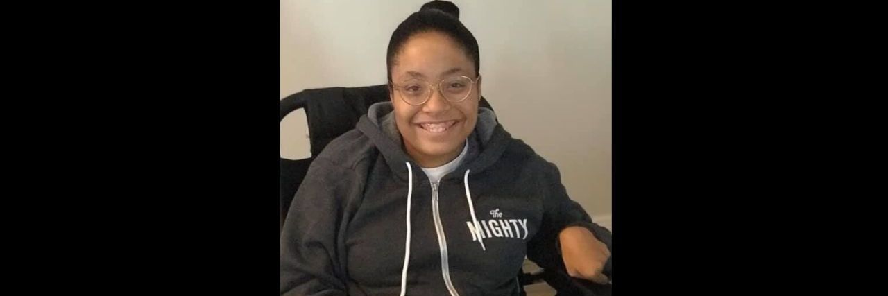 A woman wearing a sweatshirt that says "The Mighty."