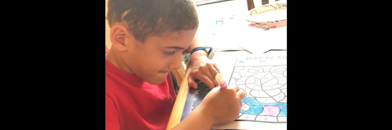 What I Realized After My Son's Haircut Revealed His Brain Surgery Scar A boy is drawing.