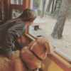 The author's daughter and her dog looking out a window