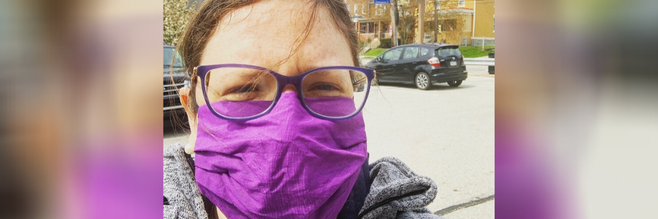 PTSD and COVID-19: Exposures Helped Me Wear a Mask A photo of a white woman with brown hair and glasses wearing a purple standing in front of Rite Aid