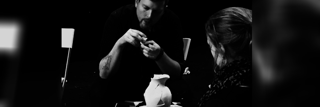 Using Performance Art to Explore Healing From Schizoaffective Disorder black and white photo of artist assembling a broken pitcher or jug