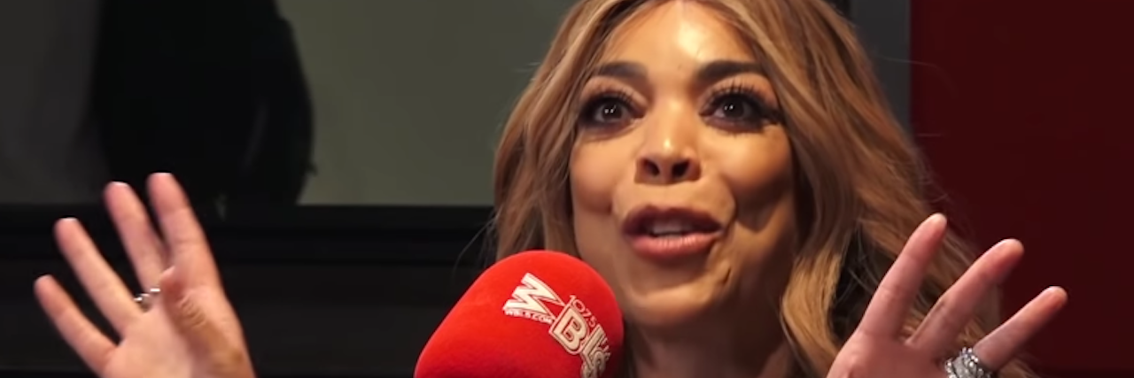 Wendy Williams speaks into a big red microphone