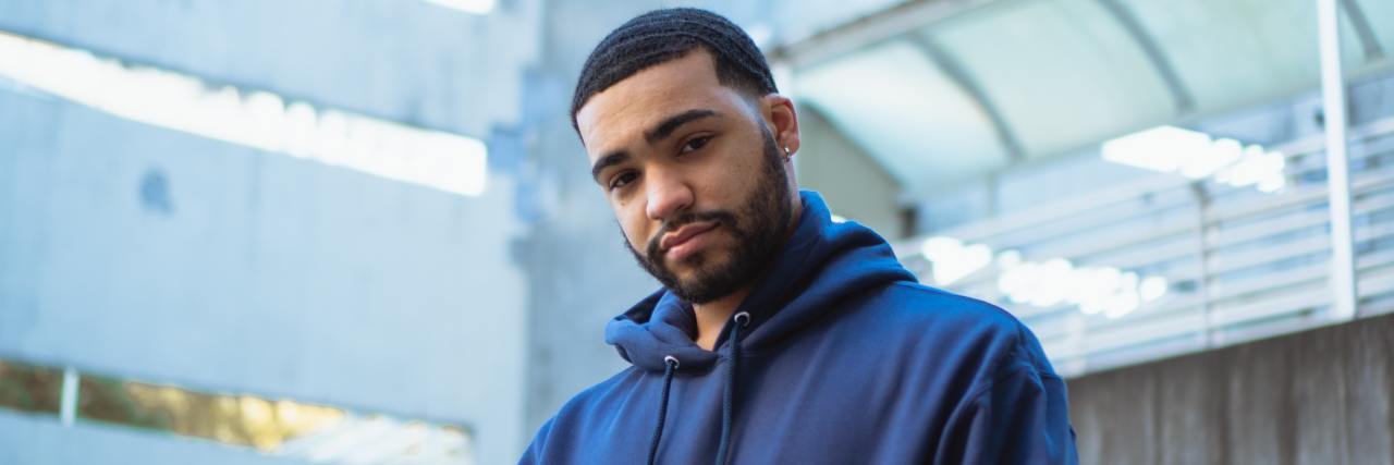 We'll Get Through COVID-19 Together, No Matter How Lonely You Feel young man in a blue sweatshirt with a slight smile