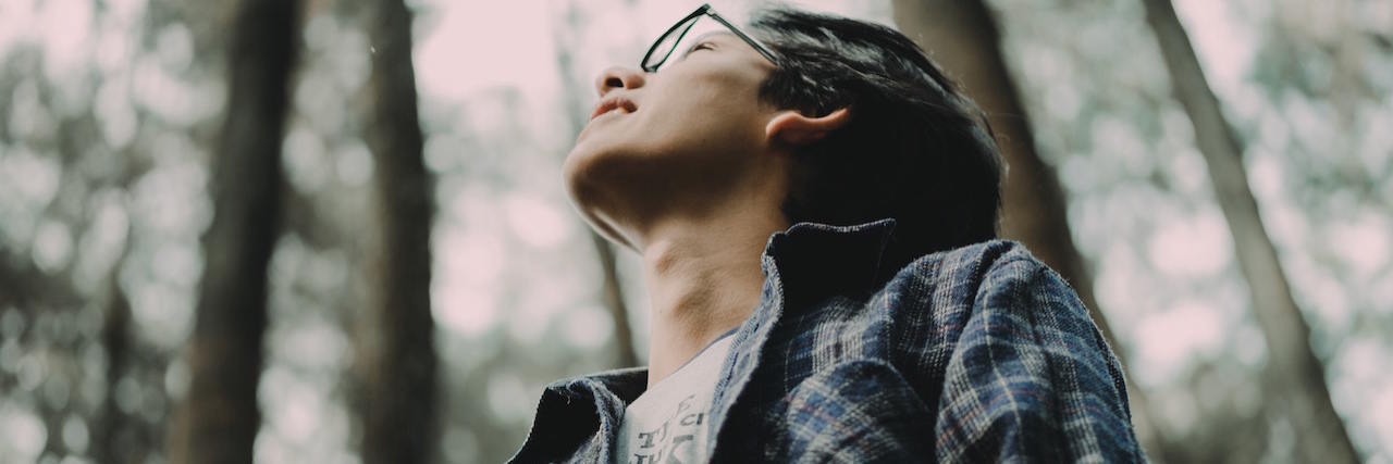 Lessons From Trying Out Self-Compassion During COVID-19 A young man in a forrest looking up