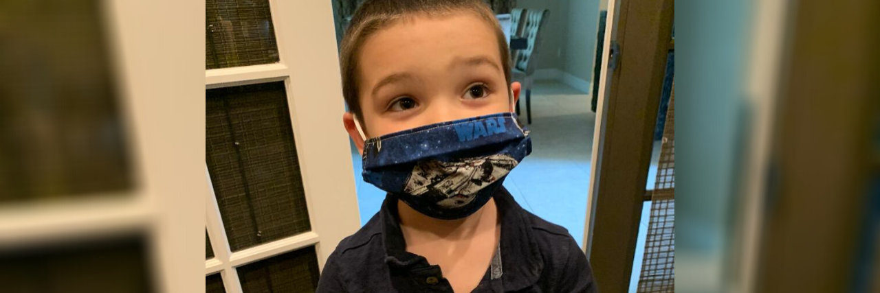 Helping a Child With Autism Learn to Wear a Face Mask During COVID-19 Amy's son on the autism spectrum wearing his Star Wars face mask.
